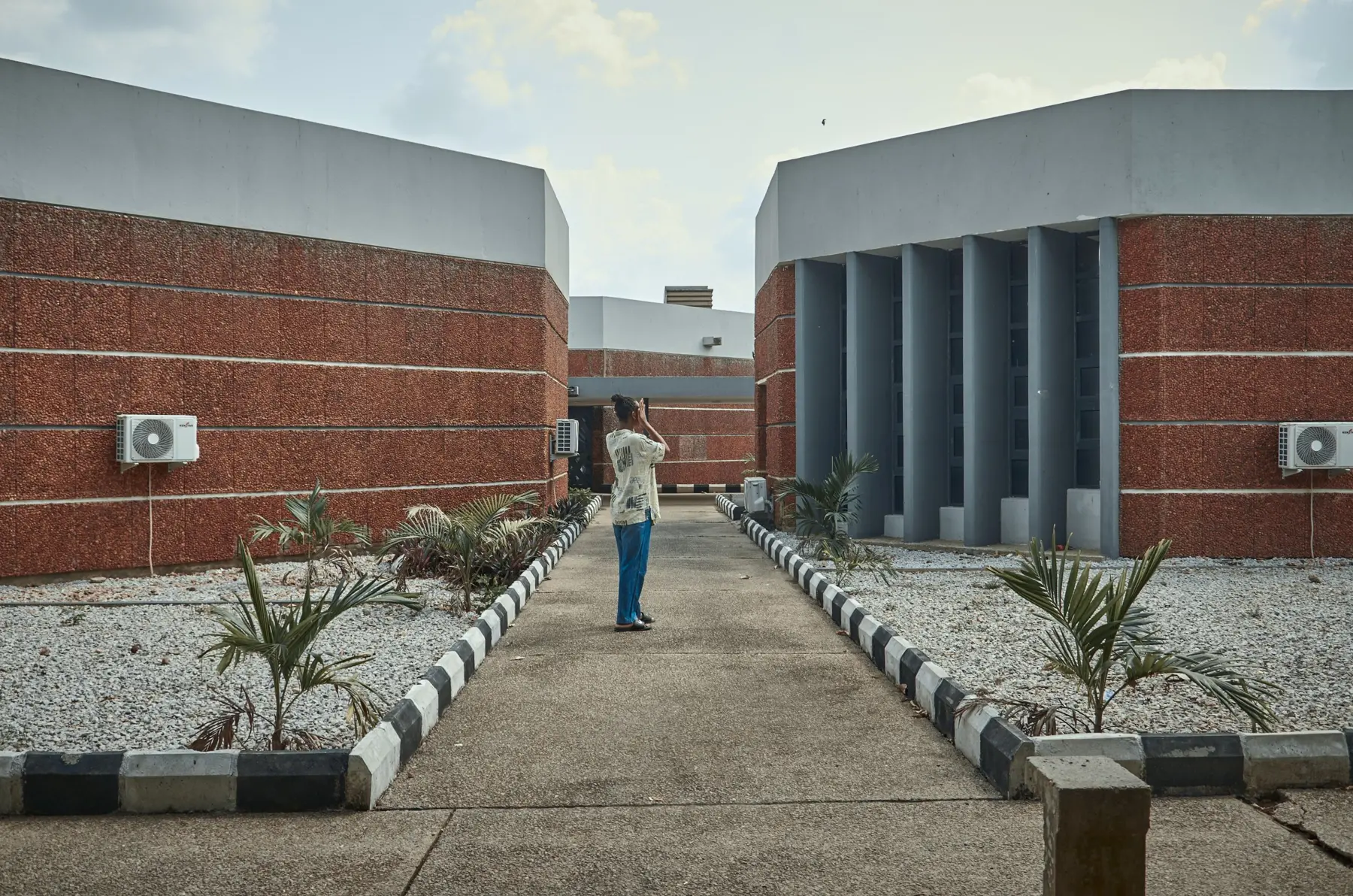 Modern brick campus buildings around a planted walkway